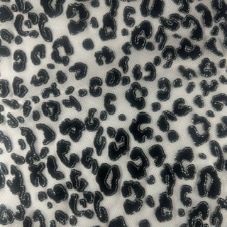 Black leopard print pattern on a white mesh fabric, showing a close-up texture of the material.