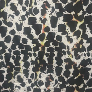 4 way Stretch tricot fabric with black and yellow spots on a beige back ground | Spandex Palace